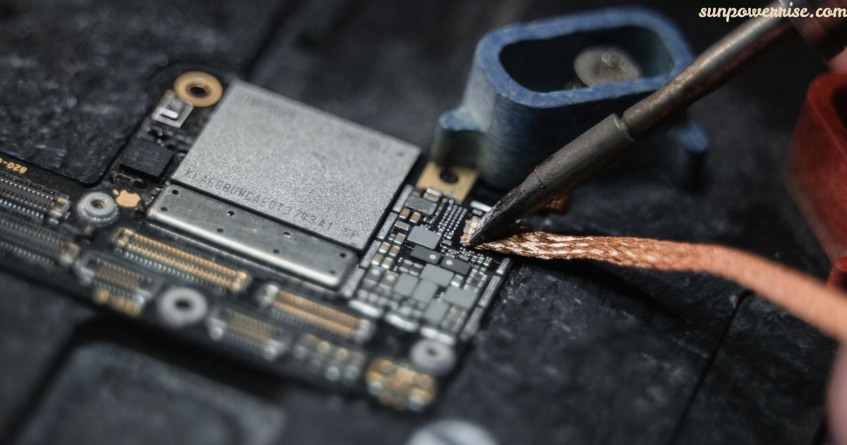 Computer motherboard repair with a technician soldering electronic components on a circuit board.