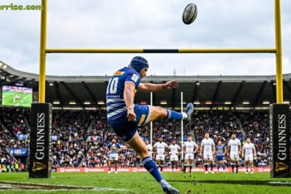 Rugby player taking a conversion kick toward the goalposts.